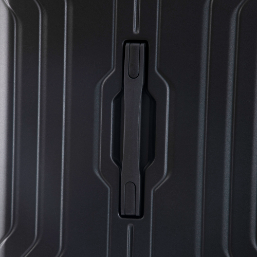 Close-up of a black suitcase handle on a textured black surface